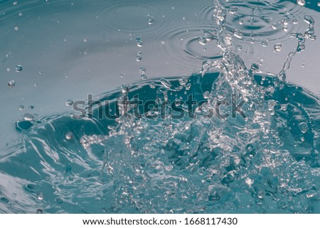 Drop of water on blue background.Water splash wallpaper.