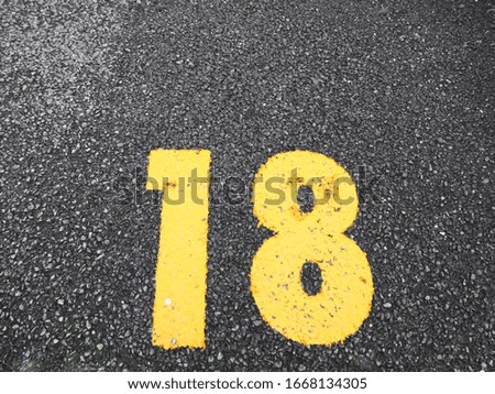 number 18 on parking slot.paint on the road.
