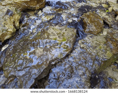 flowing mountain stream over stones in the daytime