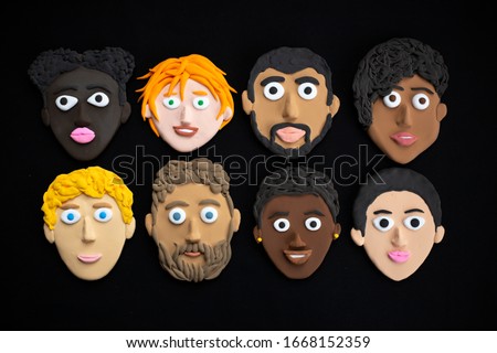 A set of international people faces with different skin eyes and hair color made with modeling clay on black background