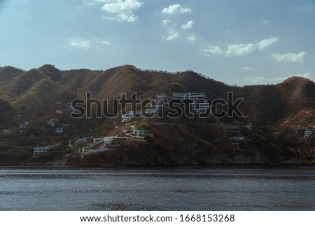 
village at the edge of the beach and in the background great mountains