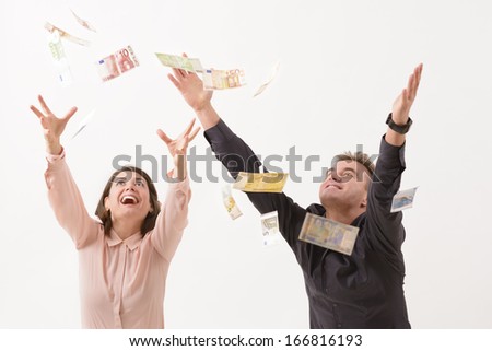 Young couple catching falling money