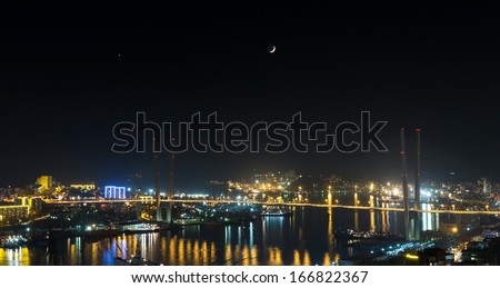 Vladivostok cityscape, night view with Venus and the Moon on sky.