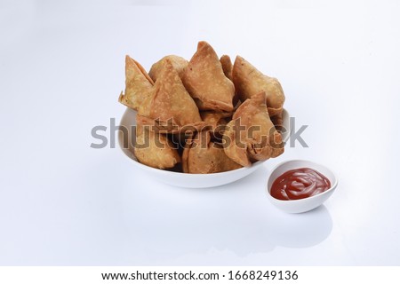 Samosa, bunch of samose placed in white bowl on white background with tomato sauce Royalty-Free Stock Photo #1668249136