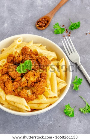 Vertical Stock photo of healthy vegan pasta with cauliflower, Fresh Parsley, Chili Flakes  on a grey background, top down Italian food, healthy food  photography.