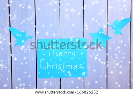 Signboard with words Merry Christmas on wooden table background close-up