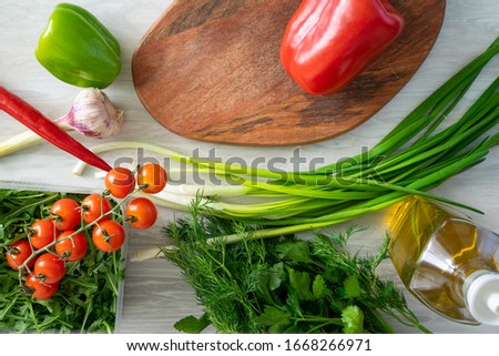 High Angle Still Life View of Knife and Wooden Cutting Board Surrounded by Fresh Herbs and Assortment