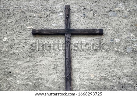 Ancient cross nailed on the wall of a building