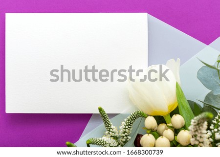 Flowers mock up wedding invitation. Congratulations card in bouquet of white flowers tulips, eucalyptus on purple background. Blank card, space for text, frame mockup,gift card. Spring festive flowers