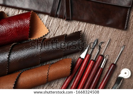 Leather samples and tools on brown table, flat lay
