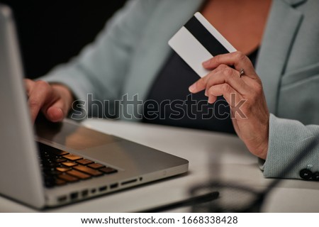 Young caucasian businesswoman sitting in her office and using credit card to pay subscription for licensed software. Royalty-Free Stock Photo #1668338428