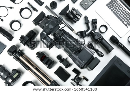 Flat lay composition with video camera and other equipment on white background