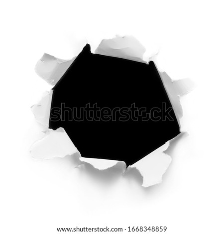 Breakthrough white paper hole. Torn ripped cardboard paper sheet round hole on black background isolated Royalty-Free Stock Photo #1668348859