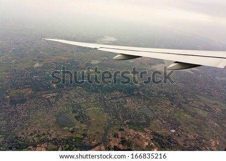 Flight flying over the clouds. Aerial shot from the sky of India. Emirates flight  wing.