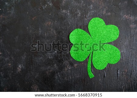 Green shamrock on a black background. St.Patrick 's Day background. Symbol of Ireland. Copy space.
