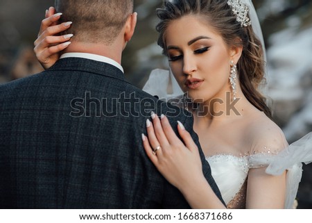 Happy young wedding couple hugging. Bride and groom. The groom turned his back. Perfect Make up. Hairstyle, wedding jewelry. Beautiful Woman