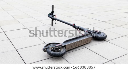 electric scooter lies on the sidewalk after accident. e-scooter concept in urban environment. Royalty-Free Stock Photo #1668383857