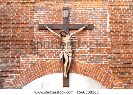 Crucifixion of Jesus Christ against a brick wall background.