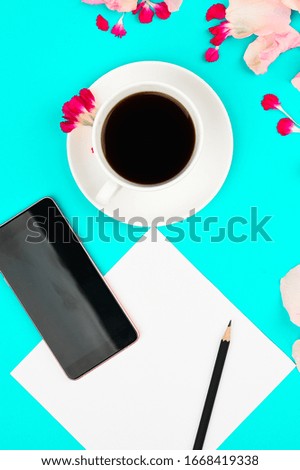 Good morning concept. Flat lay with flowers, smartphone, coffe and clean page
