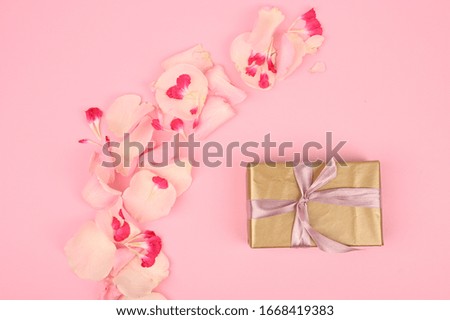 Flat lay composition with beautiful flowers and gift box on pink background. Space for text