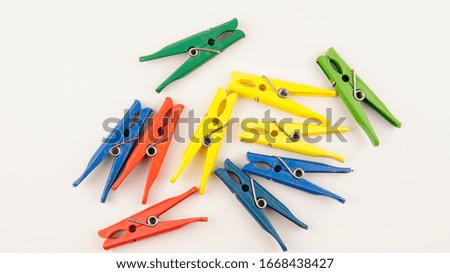     multi-colored plastic clothespins on a white background                           