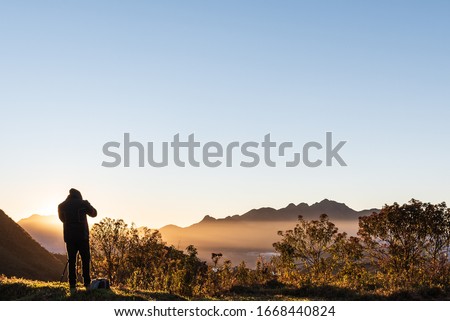 photographer taking pictures of moutain during sunrise