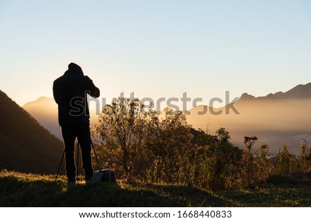photographer taking pictures of moutain during sunrise