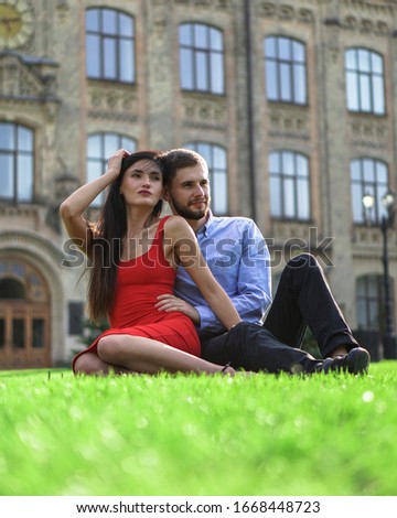 Beautiful couple of man and woman sitting and lying on the grass. Romantic theme with a girl and a guy. Spring Summer picture relationship, love, Valentine's day