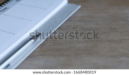 Notepad, pen closeup on wooden table. Education, planning, budgeting. 