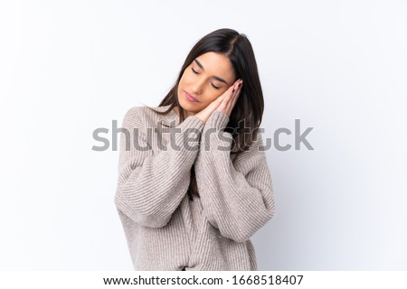 Young brunette woman over isolated white background making sleep gesture in dorable expression