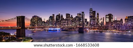 Brooklyn Bridge over the East River and the Manhattan downtown city panoramic skyline at night in New York USA