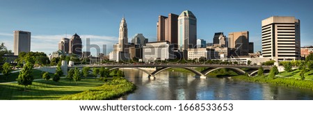 Downtown cityscape panoramic looking over the Scioto River and the Discovery Bridge along the Riverfront Park in the city of Columbus Ohio USA