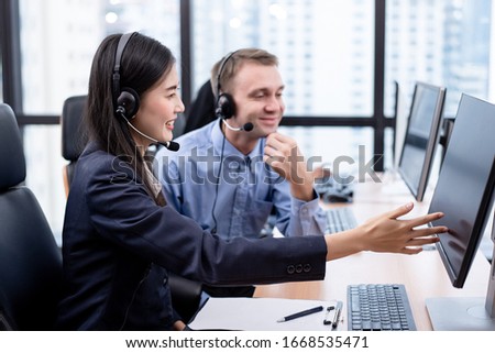 The Asian women call center is working in front of the computer with smiling face. Hot line operator support, customer relationship, service mind, 24 hours service, concept.
