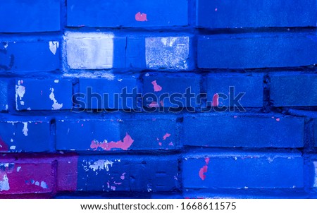 Beautiful bright colorful street art graffiti. Urban grunge bricks background with copyspace on the brick walls of the city.  Blue, neon, violet rough vinrage texture