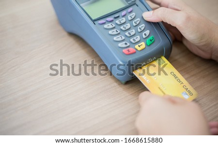 Focus swipe machine and Card, Hand Swiping Credit Card moment in-store of payment buy and sell products & service. Credit Card swipe machine.