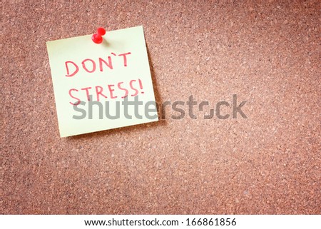 corkboard with pinned yellow note and the phrase "dont stress" written on it. room for text. 