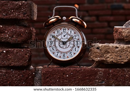 Vintage alarm clock on a red brick wall