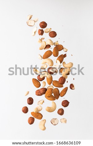 Flying nuts on a grey background: almonds, cashew and hazelnat Royalty-Free Stock Photo #1668636109