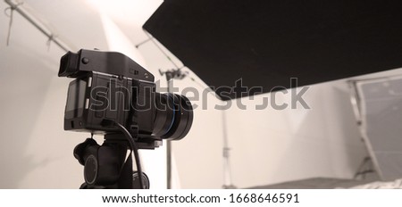 Studio medium format digital camera setup on tripod and professional equipment in studio with black and white color softbox and lighting set for still photo shooting or high resolution video or movie