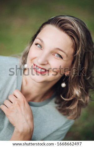 Optimistic beautiful woman smiling at camera.Blurred background.
