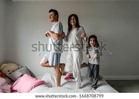 portrait of a happy family in the morning,family in pajamas,family photo,happy young family posing in pajamas at camera,dad mom and daughter take a photo as a keepsake