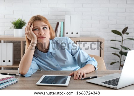 Lazy employee wasting time at table in office Royalty-Free Stock Photo #1668724348