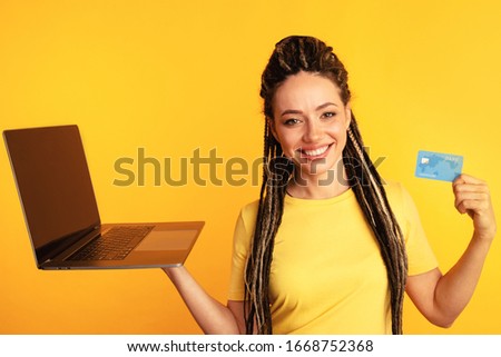 Shopping on computer. Smiling woman with laptop and credit card making purchase online.
