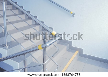 Stainless steel handrails for stairs for the disabled people.Yellow marking on handrails in the state organization for visually impaired people.focus on the railing. Selective focus