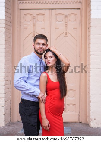 Beautiful couple of man and woman on the background of a wonderful architectural solution. Romantic theme with a girl and a guy. Spring, summer photo relationship, love, Valentine's day