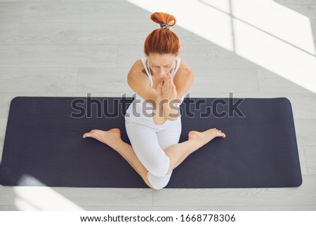 Yoga girl. Fitness girl is practicing yoga in a lotus position sitting in a studio