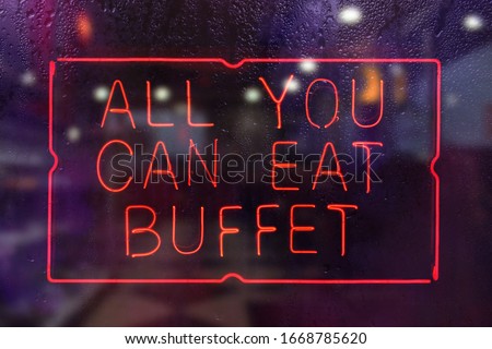 All You Can Eat Buffet Neon Sign in Rainy Restaurant Window