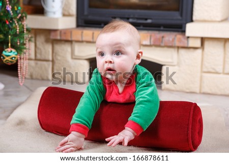 Adorable baby boy in santa clothes with christmas decoration