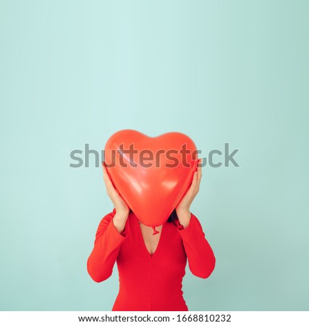 happy woman in love holding red heart shaped balloon. Valentine day and romance concept.