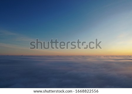 
photo above the clouds overlooking the sunrise or sunset, in the fog,